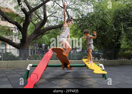 Mamma e figlia si divertiranno al parco giochi all'aperto in una nuova vita normale. Foto Stock