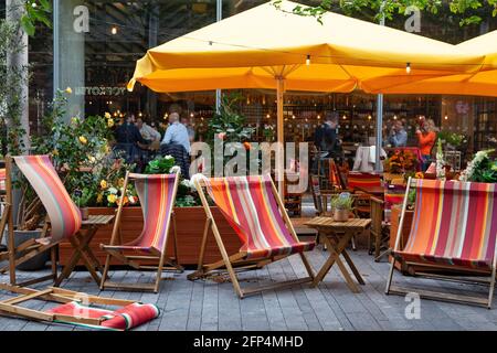 Londra, Regno Unito, 20 maggio 2021: Il tempo ventoso invia sedie a sdraio tumblingat il ristorante Refinery vicino alla South Bank. Ma a causa del recente rilassamento dei regolamenti del coronavirus i commensali sono ora felicemente all'interno, a condizione che seguano la regola di sei. Anna Watson/Alamy Live News Foto Stock