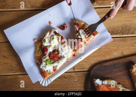 Vista aerea delle mani di una donna che mangia la pizza Foto Stock