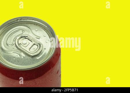 Lattina di alluminio rosso con succo o birra. Bevanda fresca in vaso rosso e gocce d'acqua, sfondo con spazio per il testo. Isolare su sfondo giallo Foto Stock