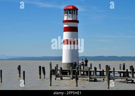 Podersdorf, Austria - 029 maggio 2021: Persone non identificate, molo e faro nella località balneare sul lago neusiedlersee una destinazione preferita per Foto Stock