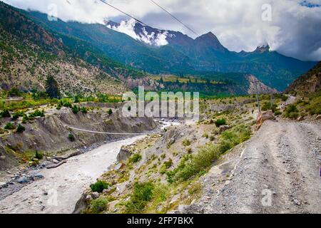 Ponte sospeso sul fiume Kali Gandaki e strada in Himalayan Montagne in Nepal Foto Stock