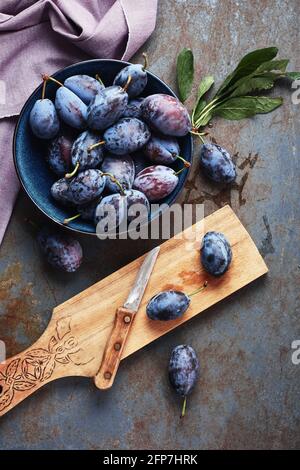 Prugne appena prelevate in un recipiente. Creazione di inceppamenti. Foto Stock