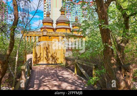 Il ponte di legno e una porta per la chiesa in legno d'epoca a Mamajeva Sloboda Cossack Village, Kiev, Ucraina Foto Stock