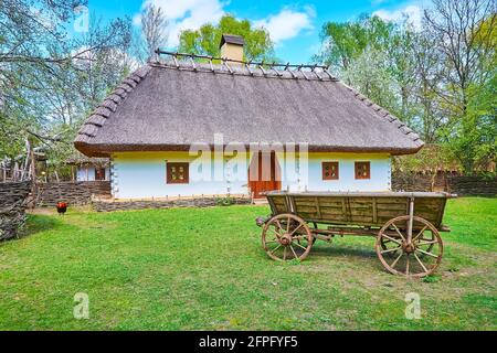 Il carrello di legno e una facciata di casa hata tradizionale di proprietà Ucraina tipica, Mamajeva Sloboda Cossack Village scansen, Kyiv, Ucraina Foto Stock