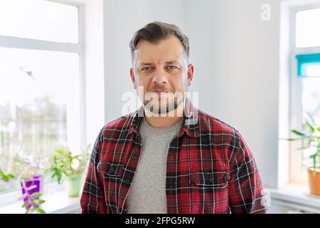 Ritratto di un uomo di 40 anni, sorridente maschio in camicia casual plaid guardando la macchina fotografica Foto Stock