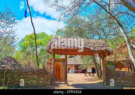 La porta medievale con tetto di paglia di fronte al tradizionale bar-ristorante ucraino, chiamato Shynok, Mamajeva Sloboda Cossack Village, Kyiv, Ucraina Foto Stock