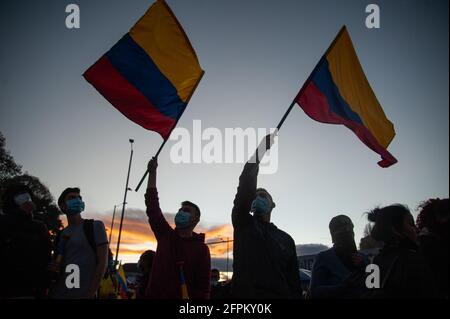 I dimostranti fanno sventolare le bandiere nazionali colombiane mentre i dimostranti si sono riuniti allo stadio El Campin Futball per protestare contro il torneo Copa America, e i casi di brutalità della polizia che hanno portato ad almeno 40 morti dall'inizio delle proteste 4 settimane fa. A Bogotà, Colombia, il 19 maggio 2021. Foto Stock