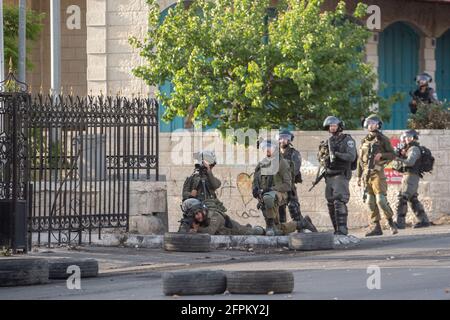 (210520) -- BETLEMME, 20 maggio 2021 (Xinhua) -- i membri della sicurezza israeliana sono posizionati durante una protesta contro i continui attacchi aerei israeliani sulla striscia di Gaza, nella città di Betlemme, in Cisgiordania, il 20 maggio 2021. Dall'inizio della campagna militare israeliana del 10 maggio, Israele ha colpito Gaza con attacchi aerei e artiglieria che hanno distrutto edifici residenziali, strade e altre infrastrutture. Secondo i funzionari sanitari palestinesi della striscia di Gaza, almeno 227 palestinesi sono stati uccisi, di cui 64 bambini e 38 donne. In Israele sono state uccise 12 persone, tra cui cinque anni Foto Stock