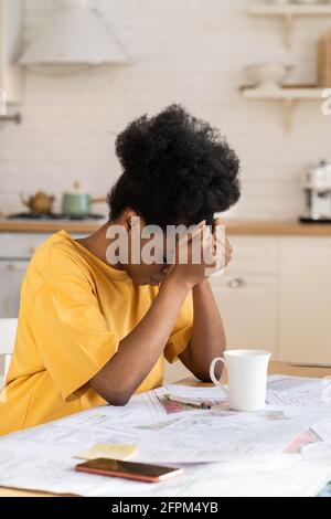 Sopraffatta giovane donna esausta, overwork afro designer stanco di lavoro con progetto remoto a casa Foto Stock