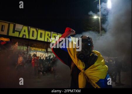 Bogota, Cundinamarca, Colombia. 19 maggio 2021. Un dimostrante che usa una maschera a gas solleva una bandiera nazionale colombiana mentre i dimostranti si sono riuniti allo stadio El Campin Futball per protestare contro il torneo di Copa America, e i casi di brutalità della polizia che hanno portato ad almeno 40 morti dall'inizio delle proteste 4 settimane fa. A Bogotà, Colombia, il 19 maggio 2021. Credit: Chepa Beltran/LongVisual/ZUMA Wire/Alamy Live News Foto Stock