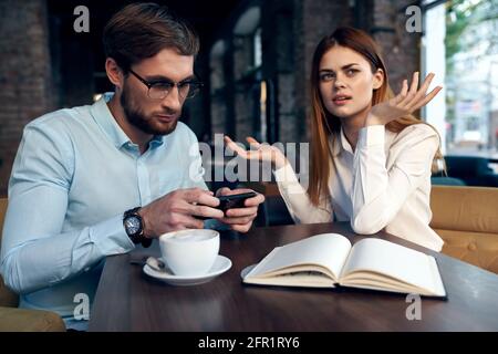 i colleghi di lavoro in una caffetteria si siedono al tavolo della colazione comunicazione Foto Stock
