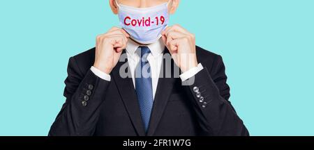 Uomo d'affari che indossa una maschera medica blu e anti-coronavirus COVID-19 pandemia concetti Foto Stock