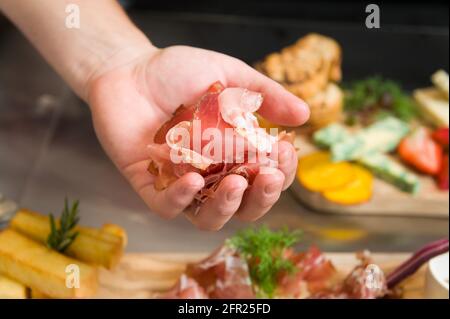 Uno chef prepara un piatto Charcuterie, o a taglio freddo, presso un ristorante Whistler. Carne, pate, formaggio e frutta. Foto Stock