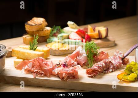 Un piatto Charcuterie, o a taglio freddo, presso un ristorante Whistler. Carne, prosciutto, porto, salame, pate, formaggio, e frutta. Foto Stock