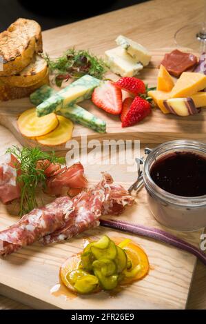 Un piatto Charcuterie, o a taglio freddo, presso un ristorante Whistler. Carne, prosciutto, porto, salame, pate, formaggio, e frutta. Foto Stock