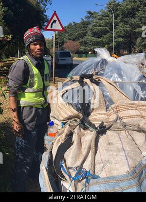 Johannesburg, Sudafrica. 17 maggio 2021. Il collezionista di rifiuti Lucky Fortuin si trova su una strada a Johannesburg. I raccoglitori privati di rifiuti in Sud Africa raccolgono e ordinano i rifiuti da vendere per il riciclaggio. Il gruppo di advocacy African Reclaimers Organization (ARO) sta cercando di dare una voce ai raccoglitori di rifiuti che lavorano per proprio conto e di migliorare il loro ambiente di lavoro. (A dpa 'Eco-surfing a 70 km/h: I freebooter del Sud Africa della società in disuso') Credit: Ralf Krüger/dpa/Alamy Live News Foto Stock