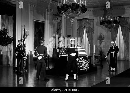 KN-30626 23 novembre 1963 il cofanetto del presidente John F. Kennedy con bandiera si trova nello stato nella stanza orientale della Casa Bianca, Washington, D.C. i membri della guardia d'onore frequentano il cofanetto. Si prega di accreditare "Robert Knudsen. Fotografie della Casa Bianca. John F. Kennedy Presidential Library and Museum, Boston" Foto Stock