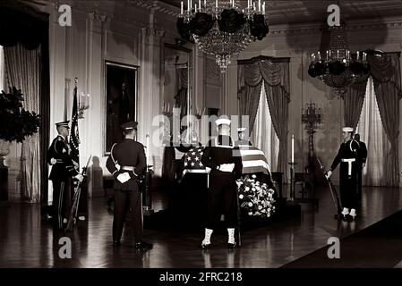 KN-30626 23 novembre 1963 il cofanetto del presidente John F. Kennedy con bandiera si trova nello stato nella stanza orientale della Casa Bianca, Washington, D.C. i membri della guardia d'onore frequentano il cofanetto. Si prega di accreditare "Robert Knudsen. Fotografie della Casa Bianca. John F. Kennedy Presidential Library and Museum, Boston" Foto Stock