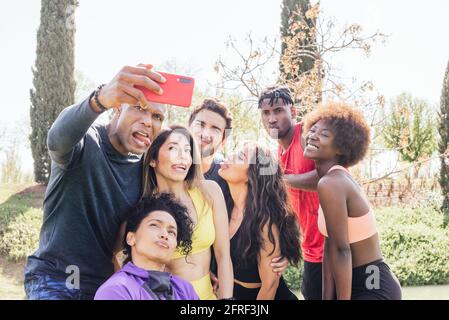 Gruppo di corridori che prendono un selfie in un parco. Creare volti divertenti. Foto Stock