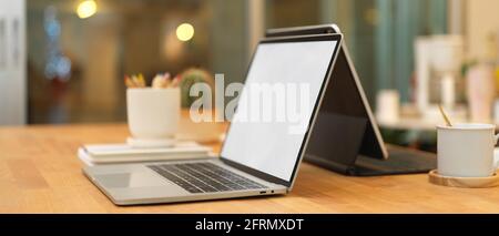 Un'immagine ritagliata di un tavolo da riunione con due computer portatili e un ufficio forniture in ufficio Foto Stock