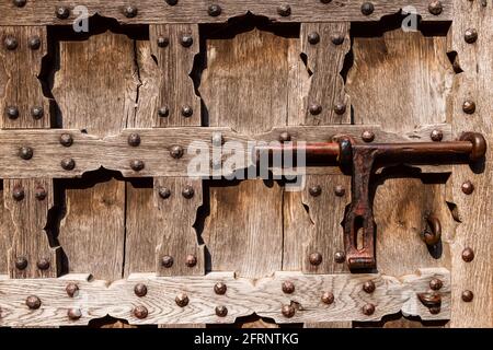 porta decorata in stile antico con intagli in legno e dettagli in metallo, sfondo in legno Foto Stock