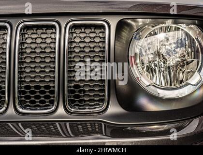 Dettaglio della griglia della parte anteriore di una jeep che mostra un faro e una parte della griglia del radiatore. Foto Stock