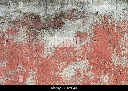 Frammento di una vecchia pelatura cracked texture di un rosso muro di cemento Foto Stock