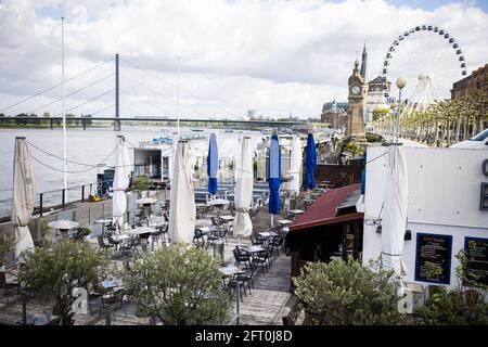 Duesseldorf, Germania. 21 Maggio 2021. Vista delle casemate ancora vuote sulle rive del Reno. Dopo un mese di pausa forzata, i ristoratori di Düsseldorf potranno accogliere nuovamente gli ospiti dal venerdì. Come in altri comuni della NRW, questo vale solo per l'area esterna. Credit: Marcel Kusch/dpa/Alamy Live News Foto Stock