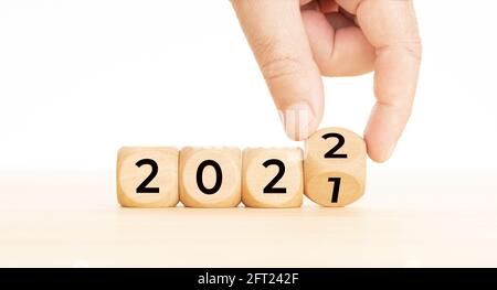 Blocchi di legno a sostituzione manuale con numero da 2021 a 2022. Concetto di anno nuovo. Spazio di copia. Sfondo bianco Foto Stock