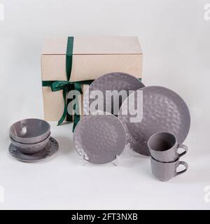 Primo piano di un set regalo con piastre per tazze di caffè e ciotole isolate su sfondo bianco Foto Stock