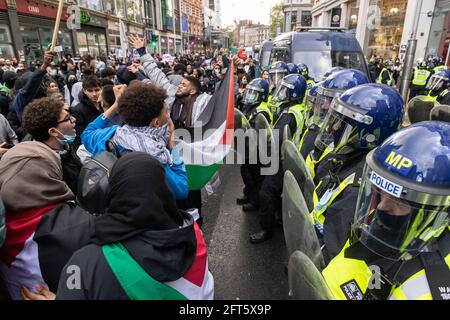 I manifestanti detengono una bandiera palestinese di fronte alla polizia, protesta della "Palestina libera", Londra, 15 maggio 2021 Foto Stock