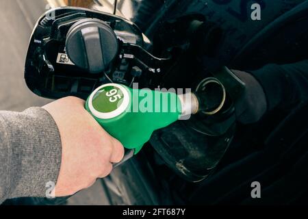 Un uomo che pompa benzina combustibile in automobile alla stazione di benzina. Foto Stock