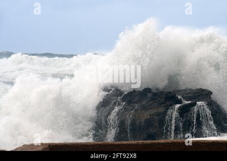 Rottura dell'onda sulla roccia Foto Stock