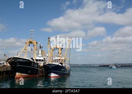 Barche da pesca ormeggiate al porto di Brixham in Devon, Inghilterra. Sullo sfondo una piccola barca taxi che porta i passeggeri a Torquay in lontananza Foto Stock