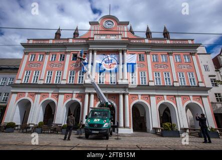 Rostock, Germania. 21 Maggio 2021. I tecnici appendono un banner della squadra di calcio F.C. Hansa presso il municipio di Rostock. Il candidato alla promozione FC Hansa Rostock, attualmente secondo al tavolo, affronterà VfB Lübeck nel finale di stagione della 3a Football League. Credit: Jens Büttner/dpa-Zentralbild/dpa/Alamy Live News Foto Stock