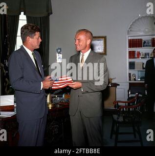 Il presidente John F. Kennedy riceve un dono di una bandiera americana dall'astronauta tenente colonnello John H. Glenn, Jr. (A destra); il Lt. Colon ha portato la bandiera nella sua tuta spaziale durante il suo volo orbitale a bordo del Mercury-Atlas 6, noto anche come amicizia 7. Sullo sfondo c'è l'assistente speciale del presidente, Kenneth P. o'Donnell. Ufficio ovale, Casa Bianca, Washington, D.C. Foto Stock