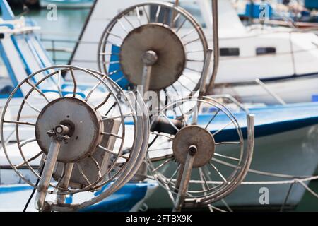 Verricelli a rete su piccole imbarcazioni da pesca blu bianco Foto Stock