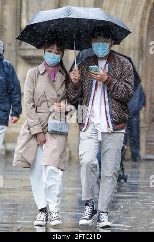 Bath, Somerset, Regno Unito. 21 Maggio 2021. Un uomo e una donna che riparano sotto un ombrello sono raffigurati fuori Bath Abbey come forti docce pioggia fanno il loro modo attraverso il Regno Unito. Credit: Lynchpics/Alamy Live News Foto Stock