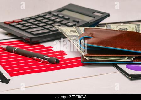 Portafoglio con dollari, carte e calcolatrice. Concetto di guadagno e successo. Foto Stock
