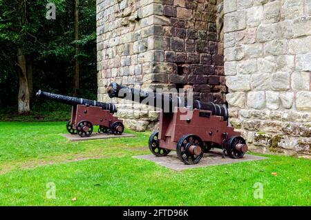 Due cannoni a nove passerelle di HMS George, affondati nell'agosto 1732, si ergono su carrozze di fronte alle torri gemelle del castello di etal Foto Stock