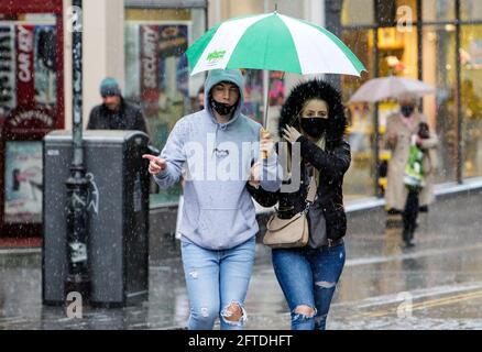 Bath, Somerset, Regno Unito. 21 Maggio 2021. Un uomo e una donna che si riparano sotto un ombrello sono raffigurati in Bath come forti docce a pioggia fanno la loro strada attraverso il Regno Unito. Credit: Lynchpics/Alamy Live News Foto Stock