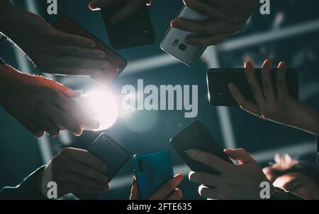 gli smartphone sono nelle mani dei giovani uomini d'affari . Foto Stock