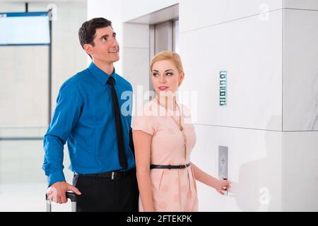 Felice coppia che aspetta l'ascensore dell'hotel o l'ascensore Foto Stock