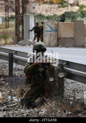 Nablus, città della Cisgiordania di Nablus. 21 Maggio 2021. Un soldato israeliano prende posizione durante una protesta a sostegno dei palestinesi a Gerusalemme e nella striscia di Gaza, in un checkpoint vicino alla città di Nablus, in Cisgiordania, il 21 maggio 2021. Credit: Nidal Eshtayeh/Xinhua/Alamy Live News Foto Stock