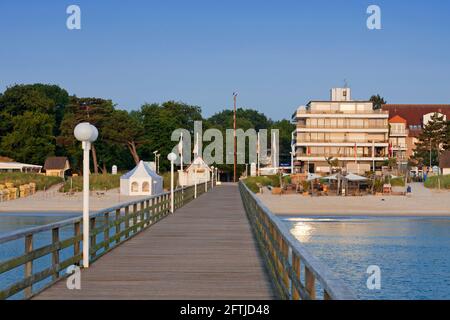 Appartamenti turistici e molo in legno / molo / Seebrücke presso la località balneare Scharbeutz, Ostholstein lungo la baia di Lübeck, Schleswig-Holstein, Germania Foto Stock