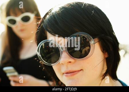 GRAN BRETAGNA / Inghilterra / Brighton /Ritratto di due ragazze adolescenti che posano in occhiali da sole. Foto Stock