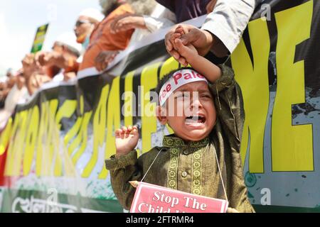 Dhaka, Bangladesh. 21 Maggio 2021. I musulmani del Bangladesh hanno messo un bambino gridante davanti alle bandiere mentre protestano contro gli attacchi israeliani ai palestinesi a Gaza dopo le preghiere di Jumma davanti alla moschea di Mukarram di Bahitl. Credit: Harun-or-Rashid/ZUMA Wire/Alamy Live News Foto Stock