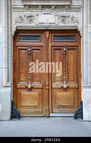 Porta doppia in legno intagliato, comunemente trovata come ingresso agli edifici di appartamenti europei Foto Stock