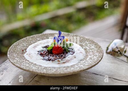 Budino di riso nero (bubur ketan hitam o bubur injun) con latte di cocco, dessert tradizionale indonesiano. Bali, Indonesia. Foto Stock